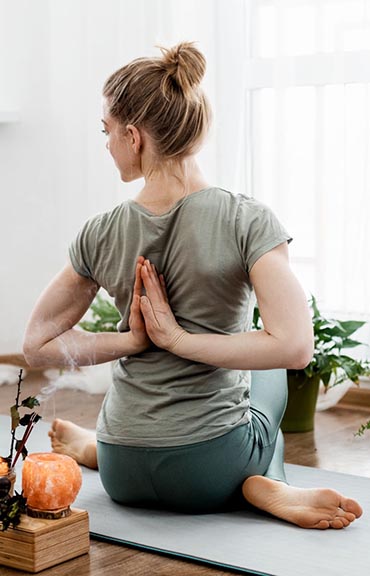 Beautiful young woman doing exercises and doing yoga at home